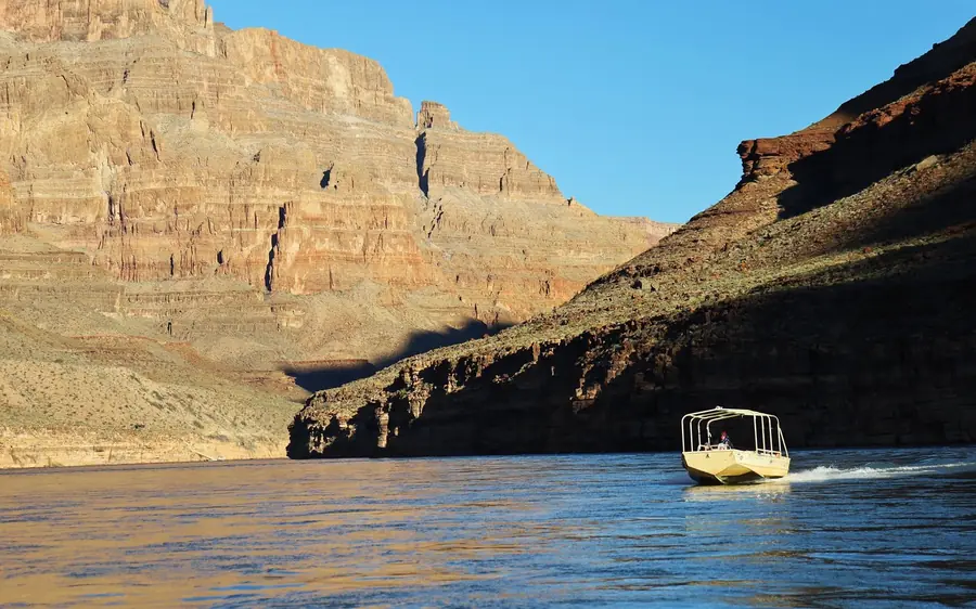 A boat on the Colorado River between the walls of the Grand Canyon